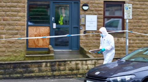 Crime scene at a house in Harrogate, with a man in a forensic suit outside