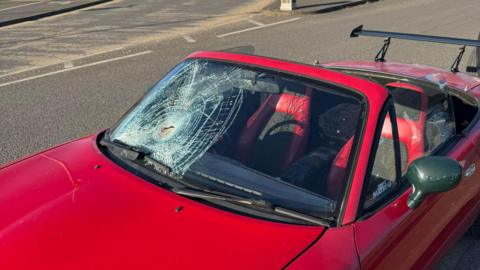 Red convertible with severe impact damage to one side