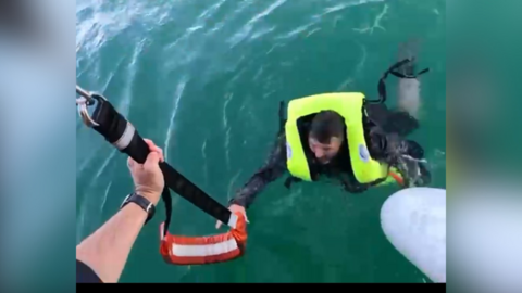 A casualty being rescued by the RNLI three miles south of Shoreham-by-Sea, West Sussex. The casualty, who is wearing a lifejacket, can be seen being pulled to safety.