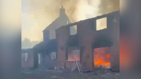 Fire raging inside of destroyed house