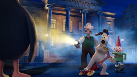 An animated scene from Wallace & Gromit: Vengeance Most Fowl. It shows Wallace and Gromit shining a torch at a chicken standing in the foreground and looking shocked. In the background there is a large building with stone pillars outside.