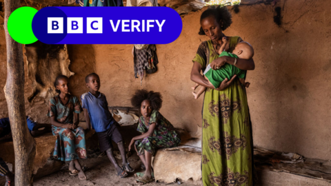 A mother holds her baby in a room with her family in Tigray