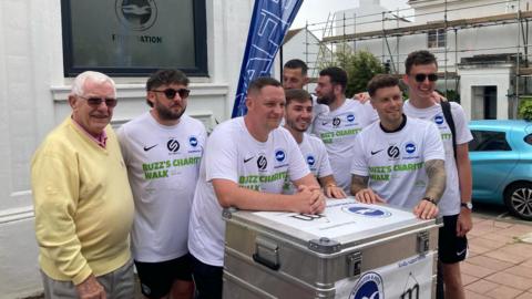 The walking team from Brighton & Hove Albion in football shirts standing outside the foundation HQ on Friday 