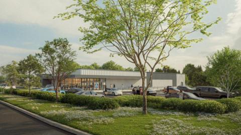 An artist impression of the new store in Devizes. It is a single storey, rectangular building, with parking spaces surrounding the building. Greenery, including trees and hedges have been planted around the car park.