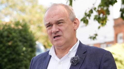 Sir Ed Davey in a navy linen jacket and a white shirt