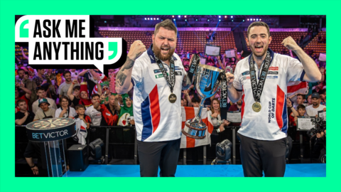 Michael Smith and Luke Humphries holding the 2024 World Cup of Darts trophy