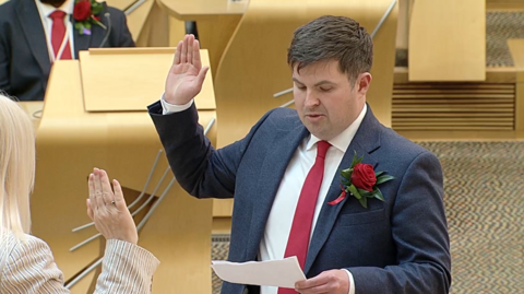BPA nan Eilean Siar, Dòmhnall MacFhionghain, a' gabhail a bhòidean ann an Holyrood Diardaoin