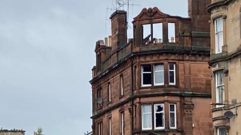 A tenement block in Perth which has been badly damaged by fire. the roof and upper windows have collapsed and several other windows are smashed.