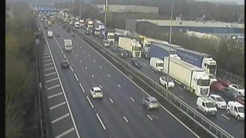 A traffic camera showing queuing traffic in one direction on the M1 including multiple lorries