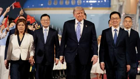 Donald Trump walks with Chinese Vice President Han Zheng and other delegates in front of Air Force One after arriving in Beijing