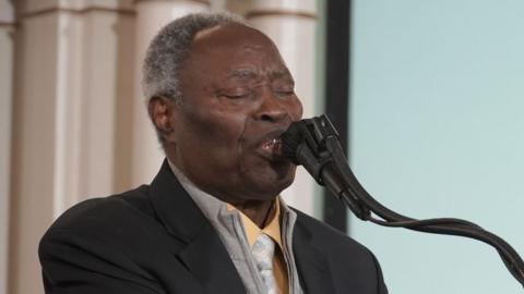 William Kumuyi standing at a pulpit behind a sign that says "Inauguration Praise and Prayer Convocation".