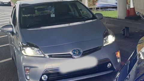 A silver car is on much of the photo.