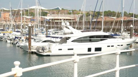 Yachts in a marina in Jersey. Most of the boats are white.
