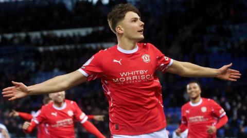 Emre Tezgel holds his arms out in celebration after scoring for Crewe