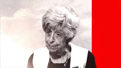 An elderly woman looks off to the left of the screen