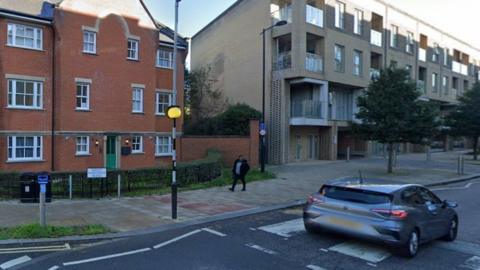 Part of Great Northern Road in Cambridge. There are flats on the road and a car driving over a pedestrian crossing