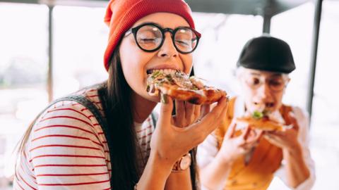 Young woman eating pizza