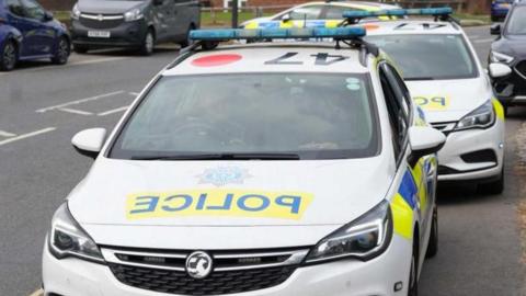 Three police cars arriving at the scene