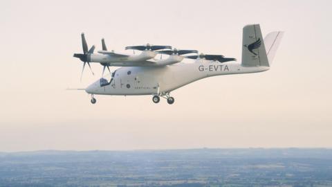 An electric vertical take-off and landing (eVTOLS) aircraft in white pictured in flight