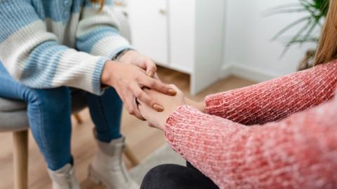 Hands of a young woman holding each other's hands together during emotional support therapy - stock photo