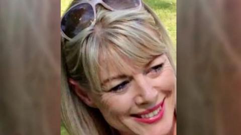 A family photo of Sarah Ashwell, who has blonde hair, red lipstick and sunglasses on her head.