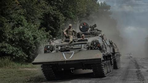 Soldiers ride a tank in the Sumy region close to the Russian border