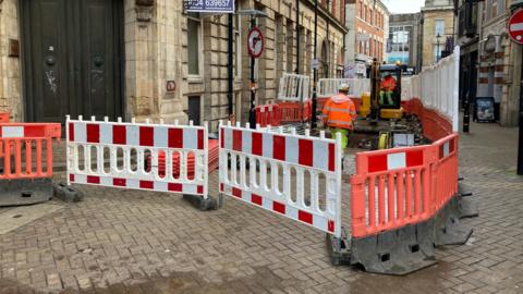 Construction workers digging up the pavement 