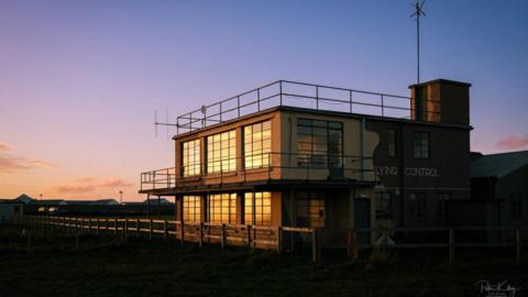 The former Air Traffic Control Centre, which is a block military-looking building, at sunset.