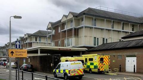 stock image showing police van and ambulances outside the hospital buildings