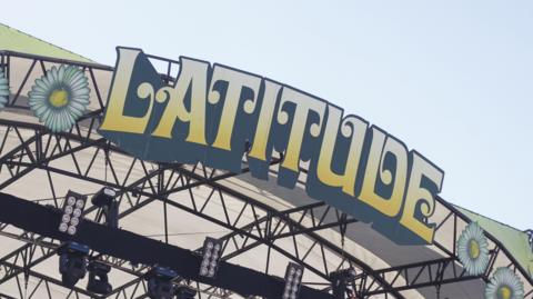 A close-up of the Latitude Festival sign on the top of a stage at the event.