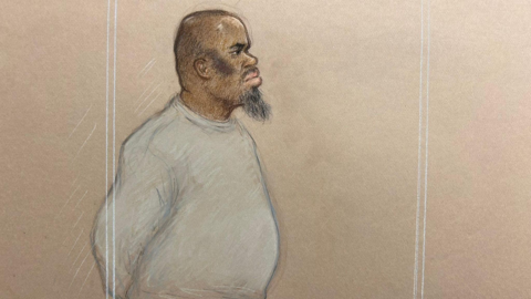 A court sketch of Essa Suleiman. He has a beard and is looking to the right. He is wearing a grey tracksuit and has a bruise on the side of his face.