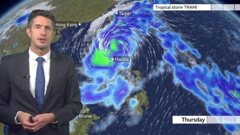 Chris Fawkes standing in front of a weather map showing the track of Storm Trami