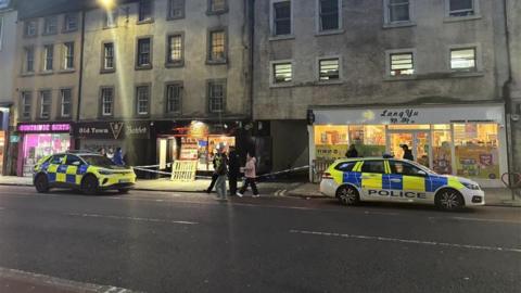 Two police cars parked next to the entrance of an alleyway on Nicolson Street in Edinburgh.