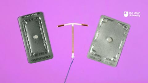 Two contraceptive pills and a copper coil against a pink background