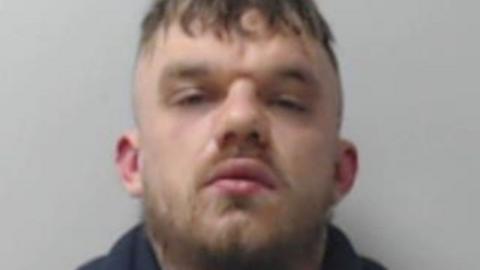 Ethan Kerr looking at camera in a police mugshot.