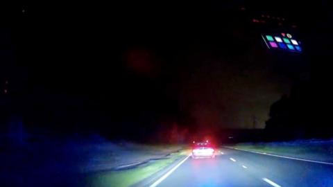 Dashcam footage at night of a speeding car along a dual carriageway