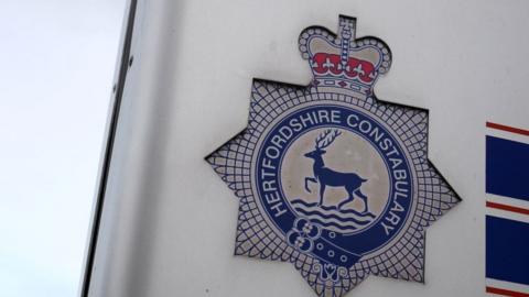 Close-up of Hertfordshire Constabulary sign featuring a blue stag near water 