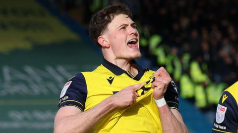 Will Lankshear points to the Oxford badge as he celebrates scoring for Oxford United in the 2-1 win over West Bromwich Albion