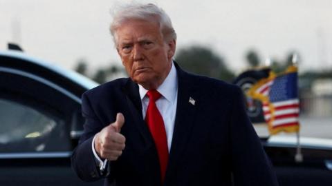 President Donald Trump gives a thumbs up as he arrives at Miami International Airport in Florida