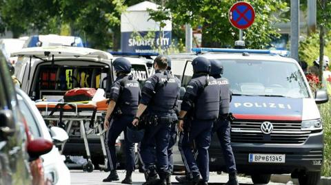 Policemen are seen in a street close to a school 