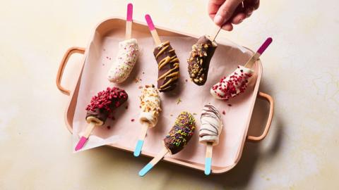 Eight banana lollies on a pink tray