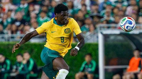 Mohamed Toure, in action for Australia, running towards the ball.