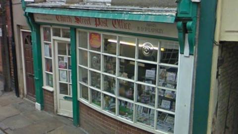An old shop front building with window frames in green and white and Church Street Post Office written across the top