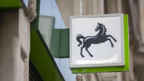 A sign of Lloyds bank, which is a black horse rearing its head on two legs