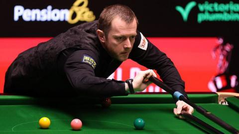 Mark Allen plays a shot with the rest