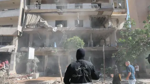 A Lebanese security serviceman stands near the site of an apartment targeted by an Israeli airstrike in Beirut's southern suburbs, Lebanon, 14 June 2026.