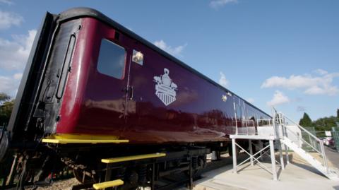 the redesigned train carriage, with steps leading up to the doors