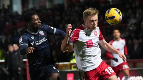 Harvey White of Stevenage holds off Jordi Osei-Tutu of Bolton Wanderers