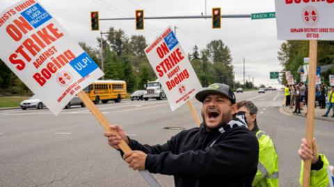 Workers with picket signs saying "on strike against Boeing" outside the Boeing Co. manufacturing facility during a strike in Everett, Washington, US.