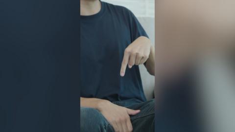 A man points at his crotch area.